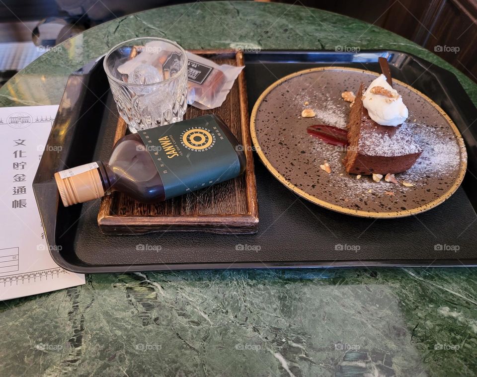 Fresh cream with chocolate cake and glass bottle of coffee