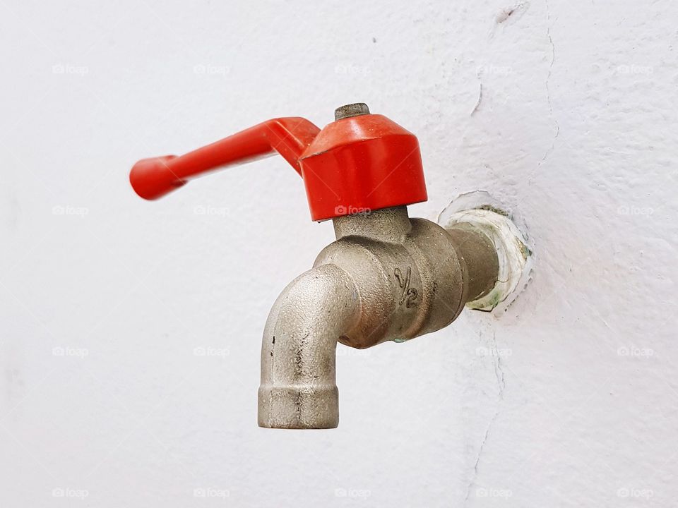 Red faucet household fixture in house
