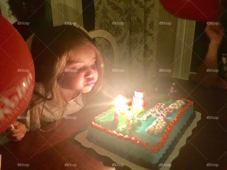 Girl blowing out birthday candles 2