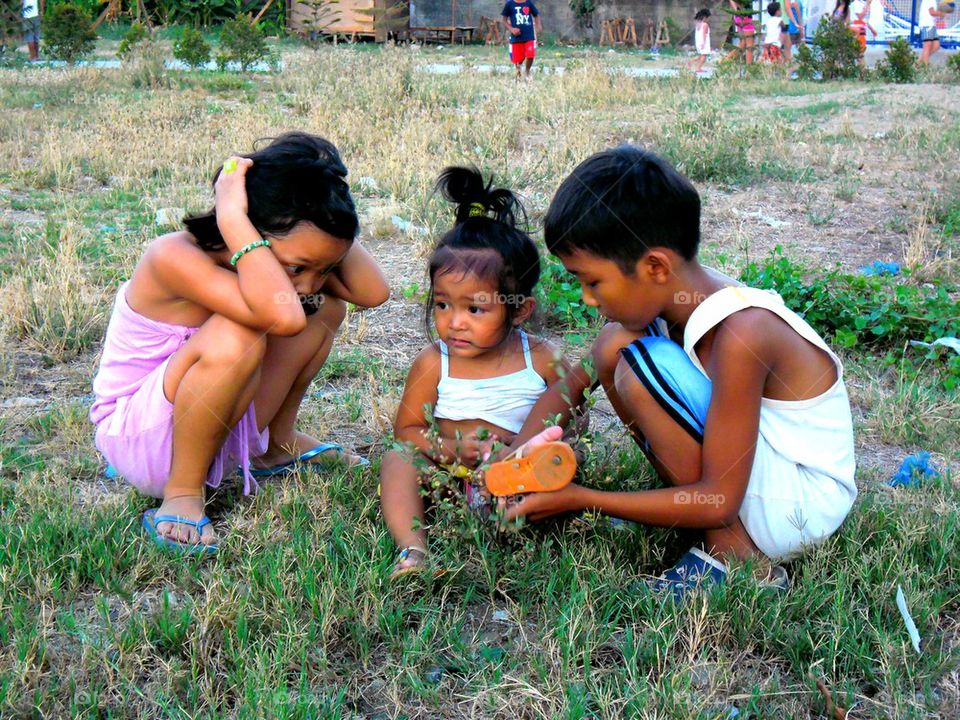 young asian children in an open grass field