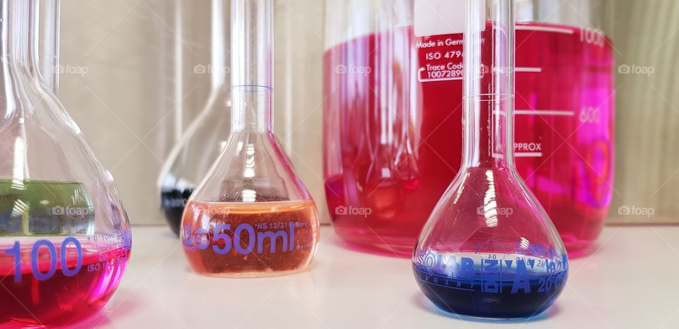 Vreating colors using chemistry. Volumetric flasks filled with colorful solutions.
