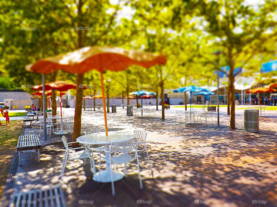 Courtyard Umbrellas Outside Crown Center, Kansas City. These serene scene is located across from Crown Center in Kansas City in a large, open courtyard. I used a tilt shift effect to make the umbrella in the foreground stand out.