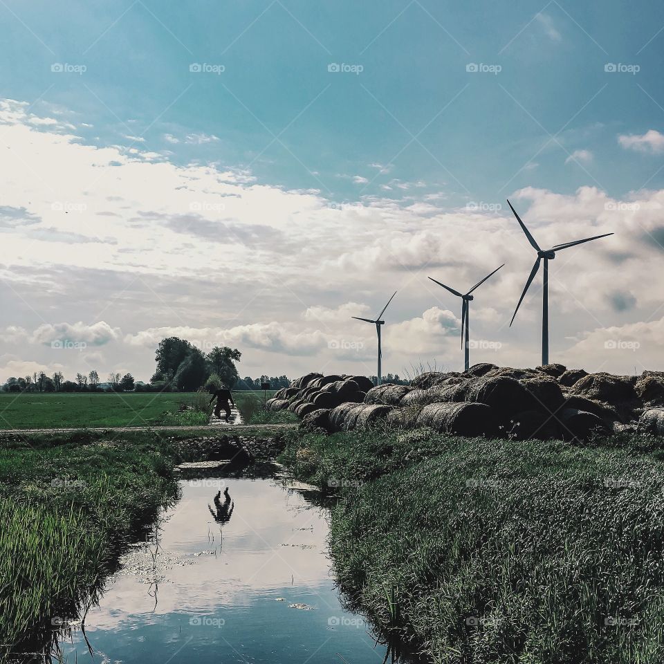 Wind turbines with haybales on field