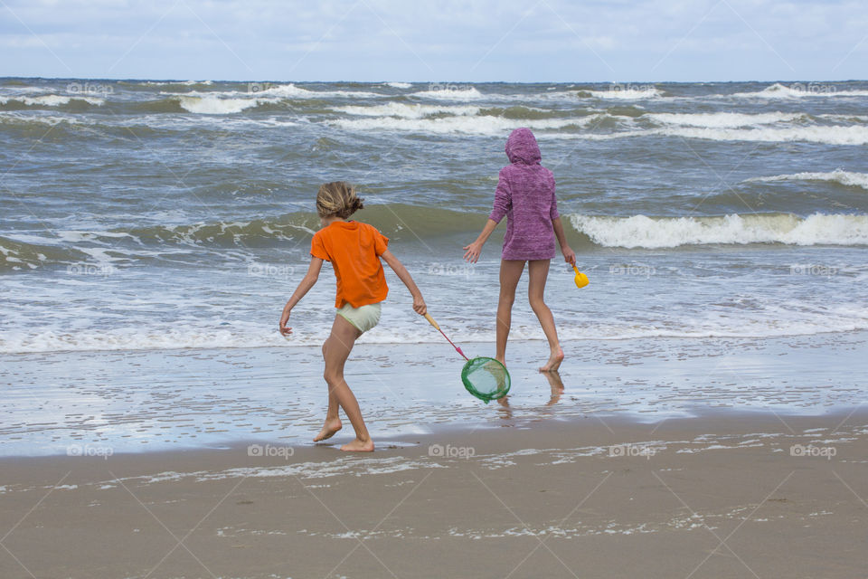 Girls playing on the beach on a windy summer day 