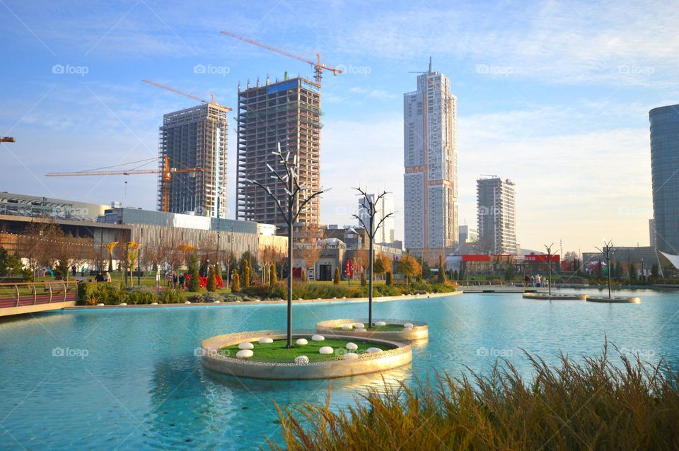 swimming pool on the background of the city pier with blue water skyscrapers in the background