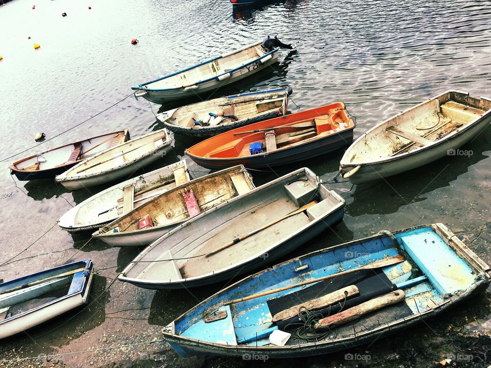 Assorted rowing boats, floating at Mevagissey harbour. 