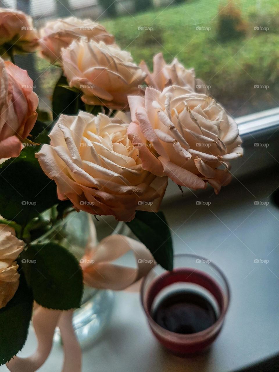 Perfectly beautiful and tender pink roses in a glass vase near the window and cup of fresh coffee