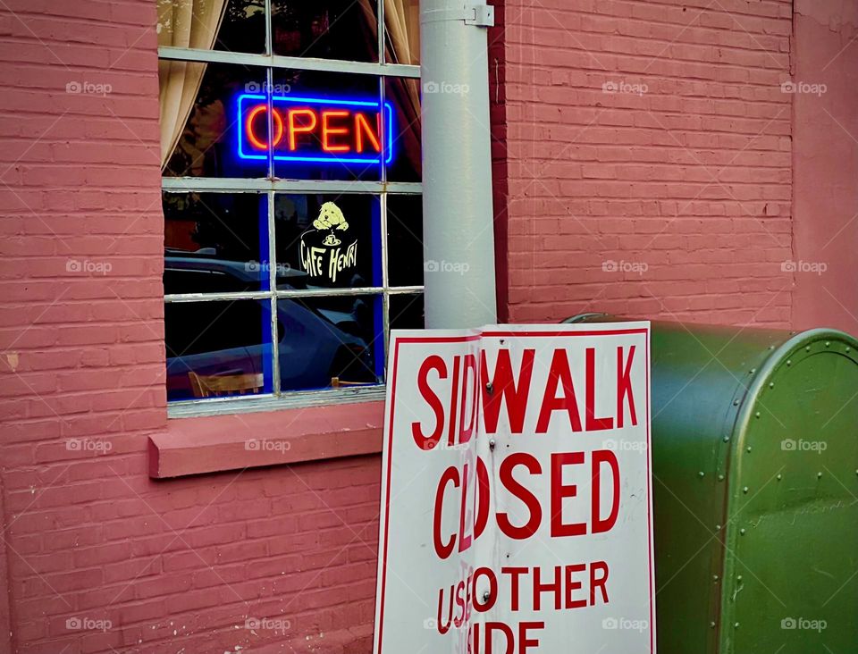 The inviting “OPEN” neon sign shows all who see it that the bar / restaurant is currently open for business. Who cares that the sidewalk is closed. There will be a way to venture over there real quick - or not. 2022. Hypnotic Productions