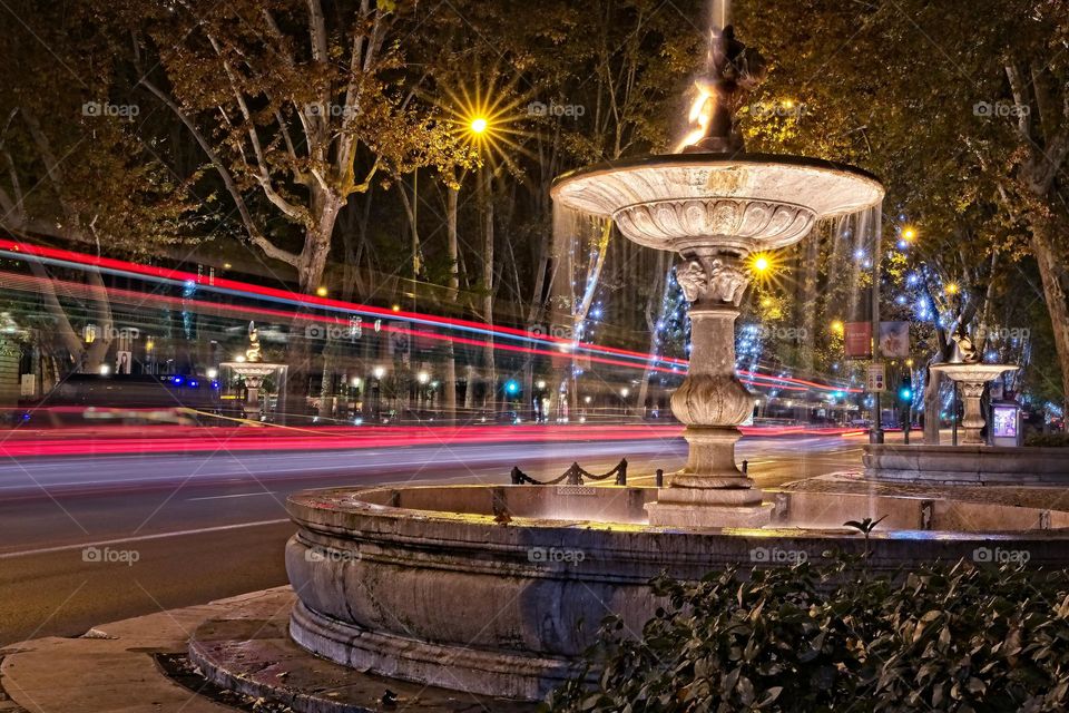 Illuminated fountain next to traffic