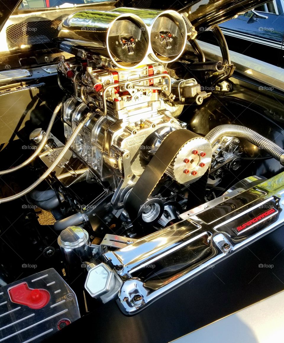 A 1970 Chevrolet Chevelle with a blown motor sits on display at a car show