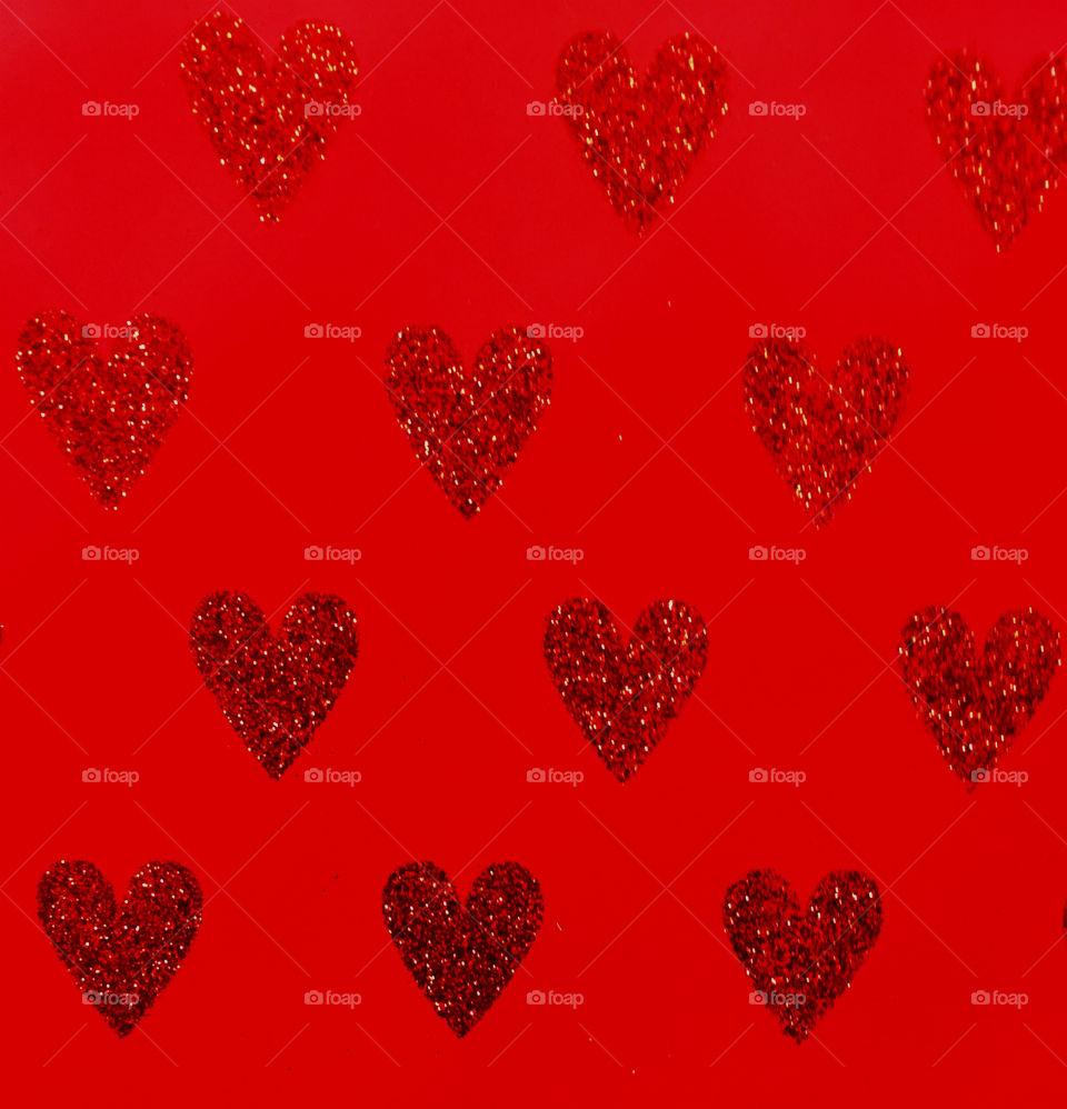 Glitter heart shape against red background