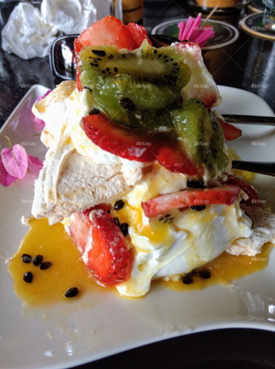 Pavlova with mixed fruits, colorful dessert, tropical, kiwi, strawberry, passion fruit, sweets, airy meringue, plate, delicious, restaurant