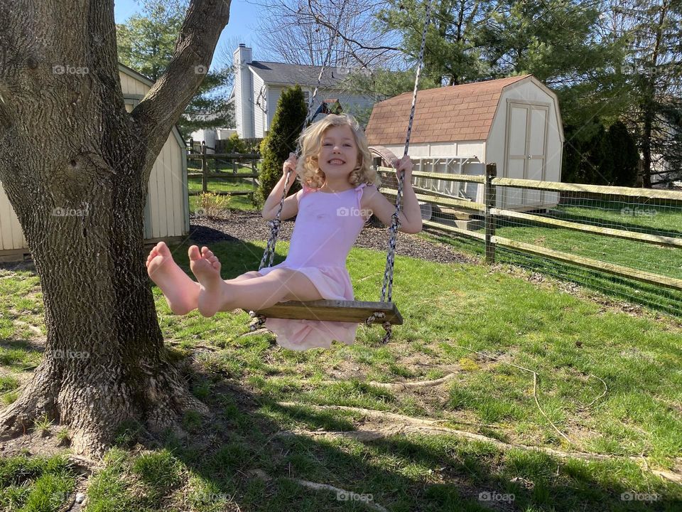 Summertime fun swinging on a tree swing 