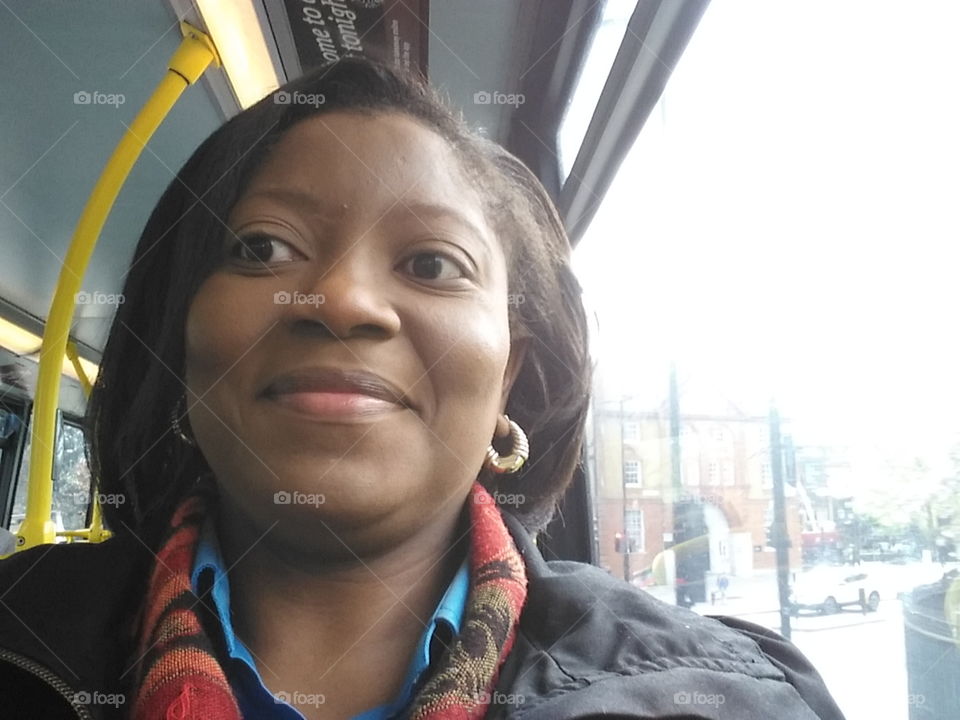 Woman on a London bus wearing a coat and scarf