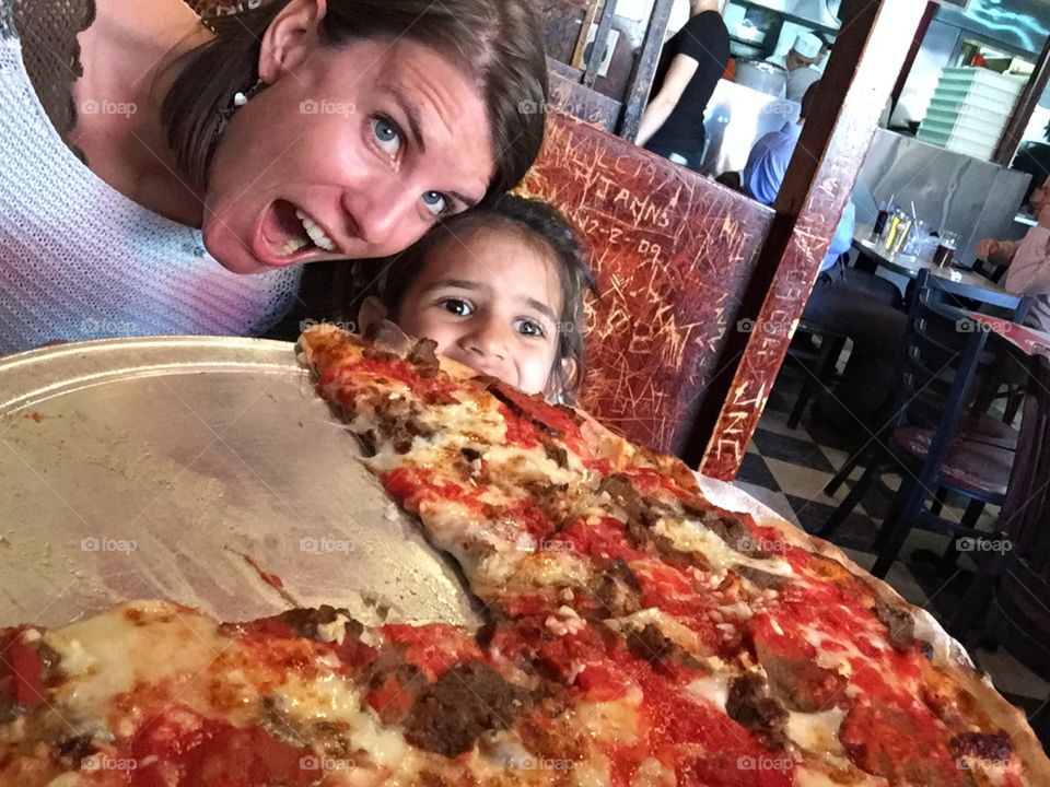 Mother & Daughter PizzaTime. Tucking into a gigantic New York Pizza