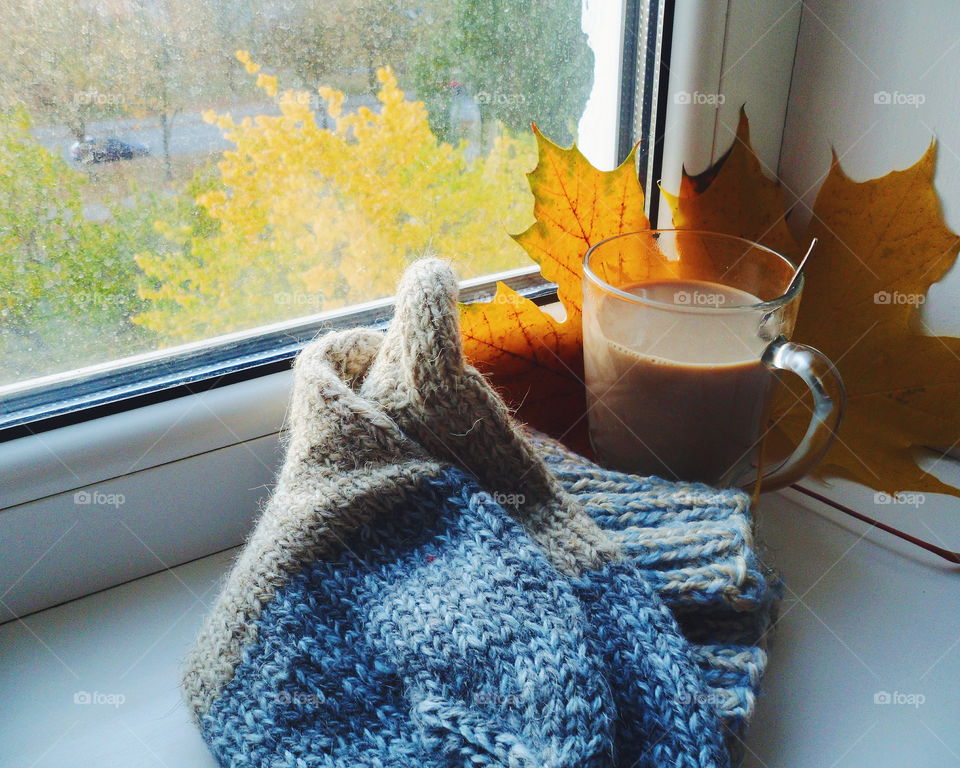 a cup of hot chocolate and warm socks on the windowsill