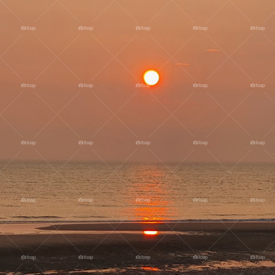 Beautiful red sunset over the water of the Maasvlakte in the Netherlands.