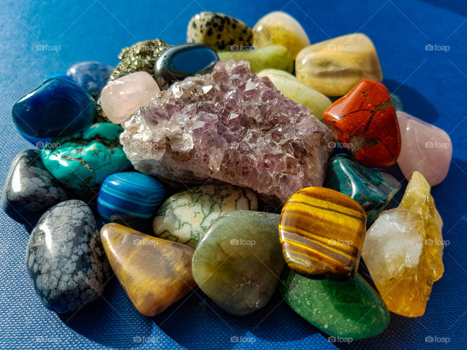 large selection of gem stones with larger Amethyst in center.