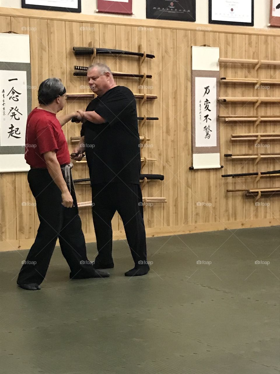 Martial arts training at the dojo. The sensei (left) is teaching the student (right) a counteractive combat technique that would save his life in the future.