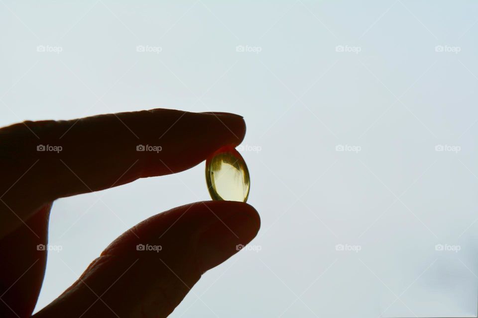 vitamins capsules oil in the hand white background