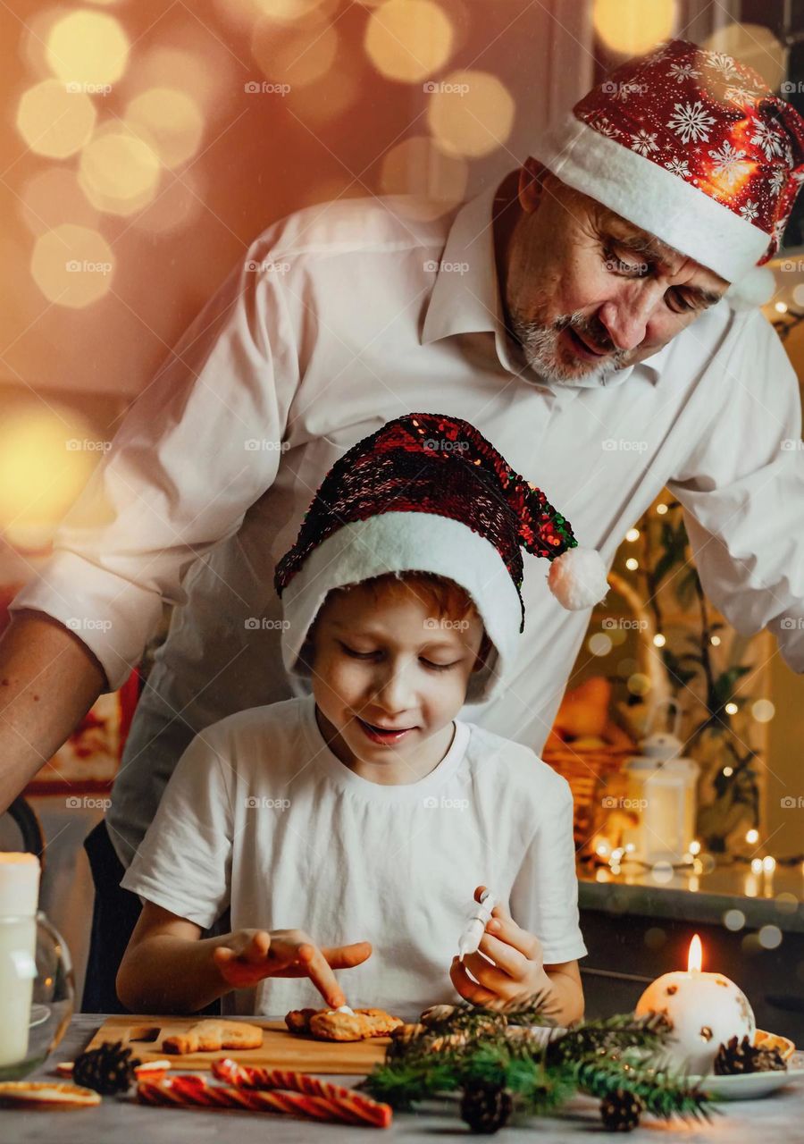 Father and son spend fun cooking christmas cookies at home in the kitchen, lifestyle