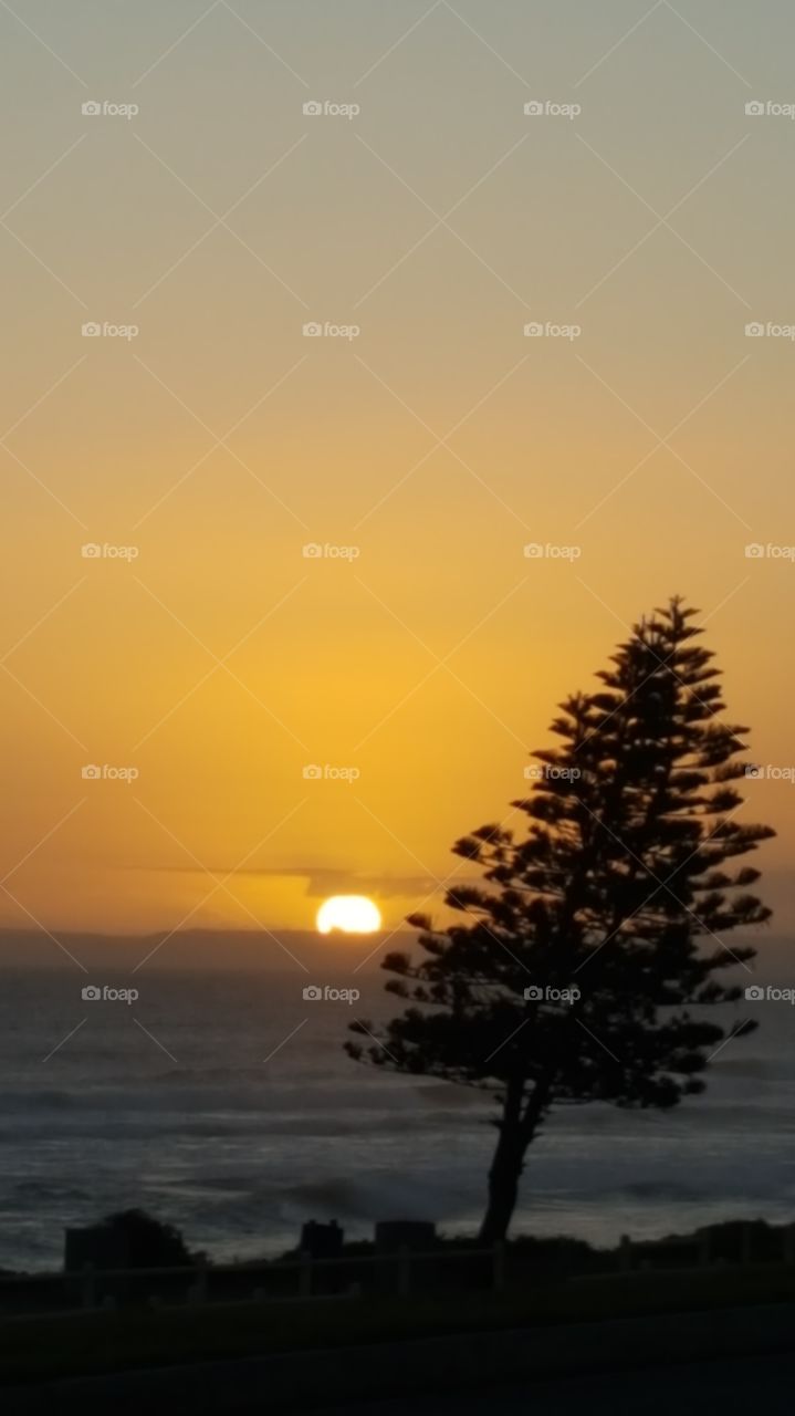 Sun setting over the ocean in Glentana