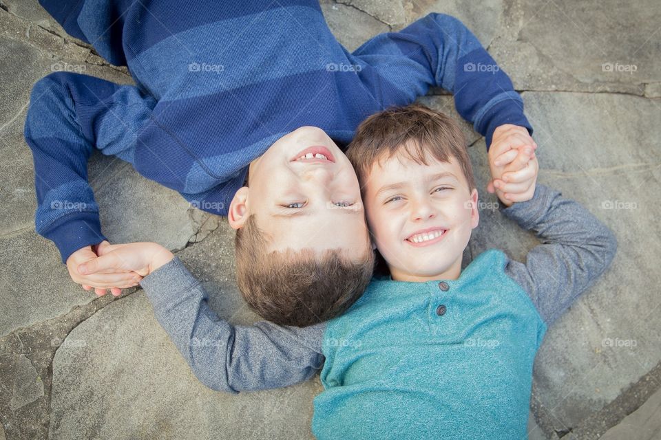 Brothers posing on backs smiling