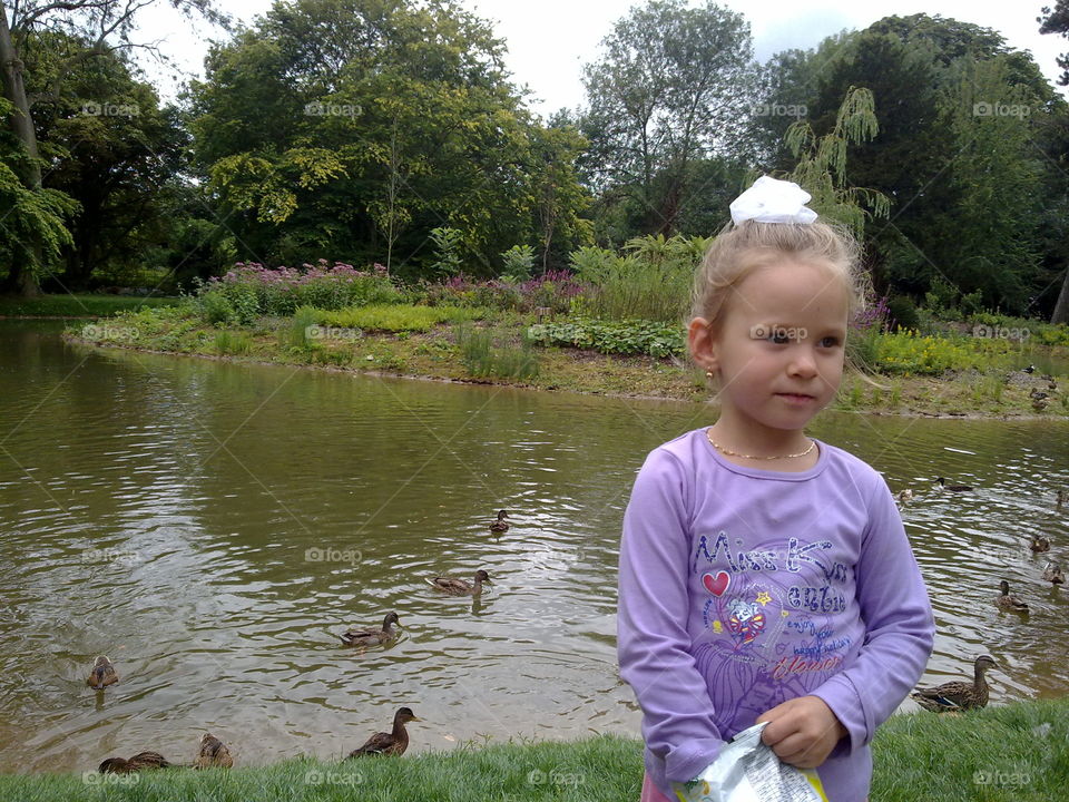 Cute girl standing near lake