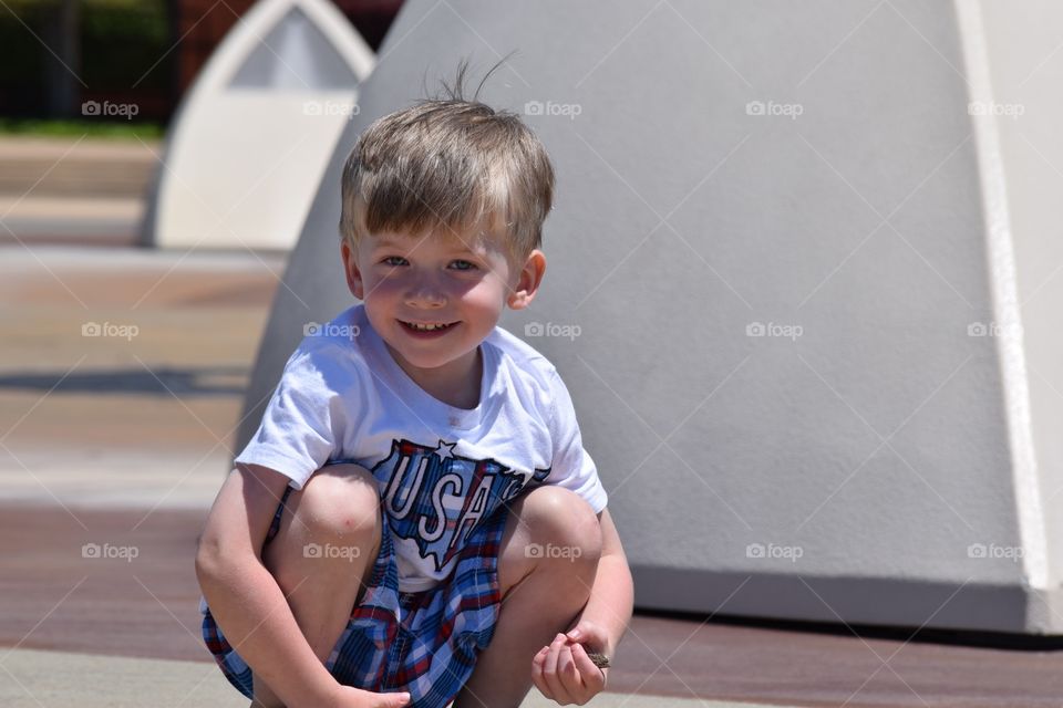 Boy posing for camera. Toddler smiles 