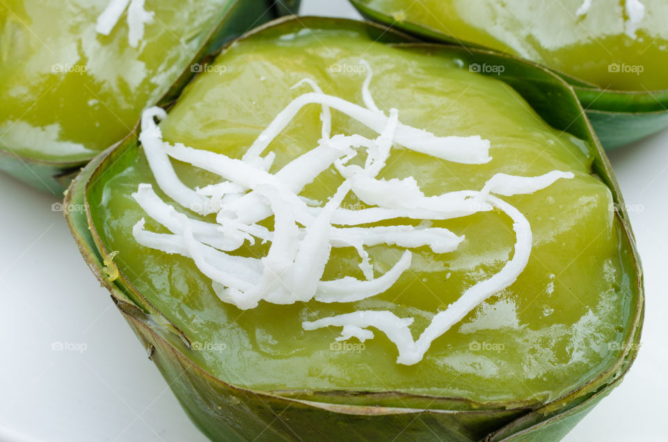 Dessert of Thailand known as "Kanom Piak Poon Bai Tuey" or pandan sweet pudding. Garnish with grated coconut.