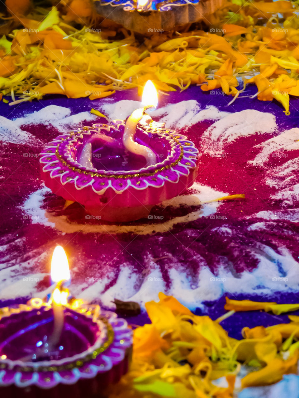 Colourful attractive decorative Diya or earthen lamp is used in Indian festival Diwali .Diya put on Rangoli with flower petals.