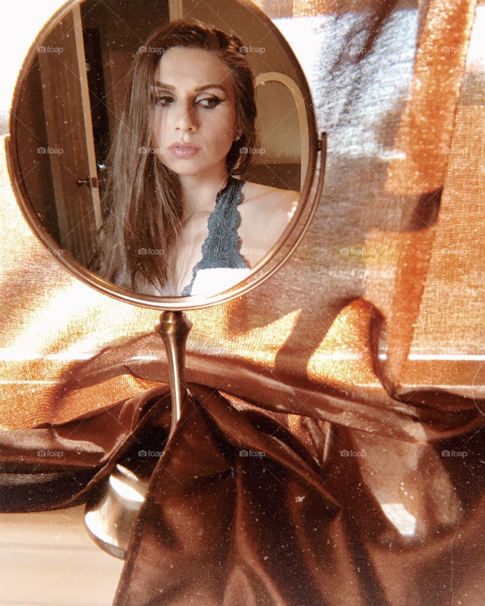 Brunette woman reflection In mirror looking down 