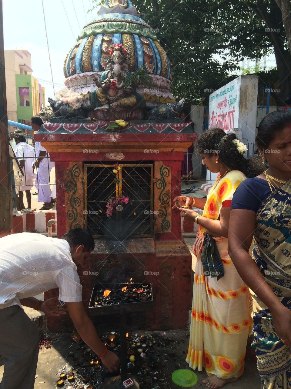 Indian people praying in front of god vinayaga temple 