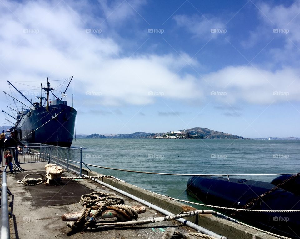 Alcatraz island on horizon with ship docked 