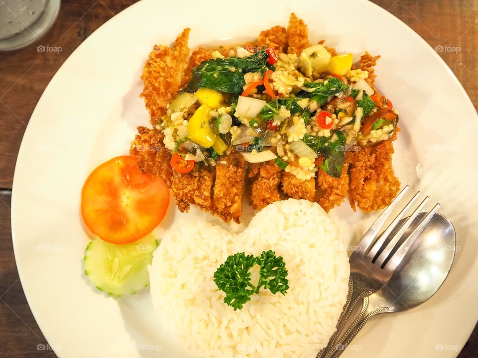 Thai spicy food heart shape rice topped with fried pork and basil