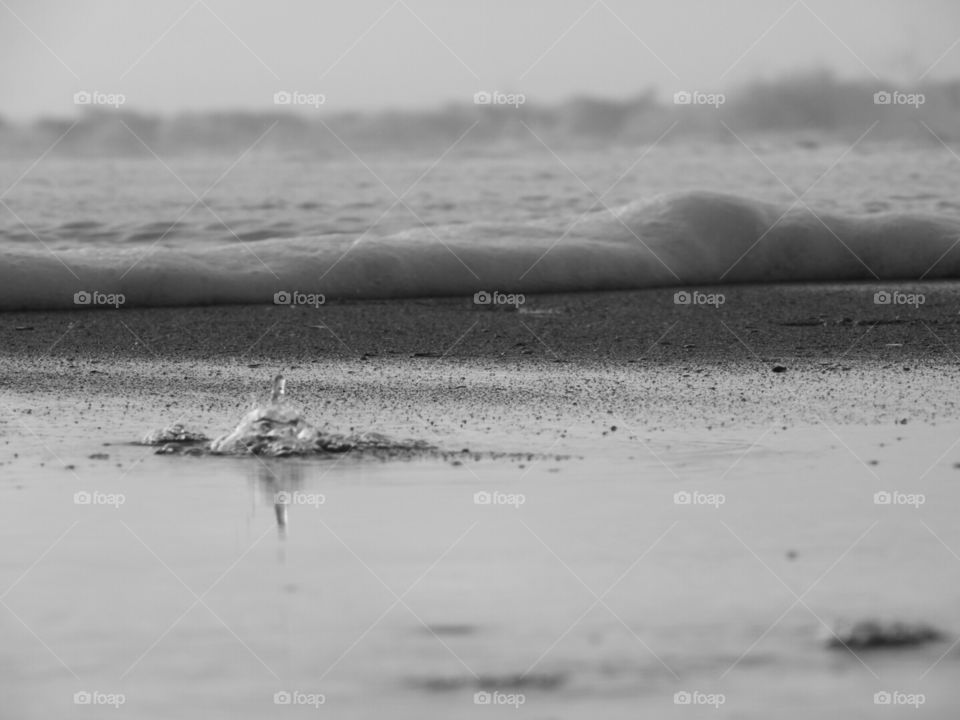 Water captured bubbling up through the sand. Abstract.
