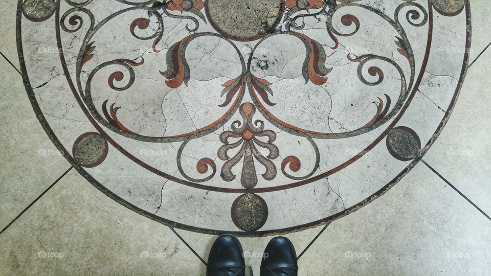 Standing by a floor design.