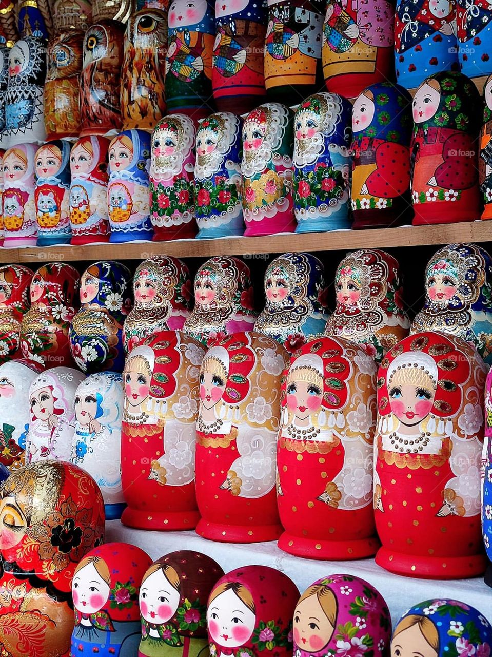 Happiness.  On the shop window there are rows of multi-colored smiling nesting dolls,