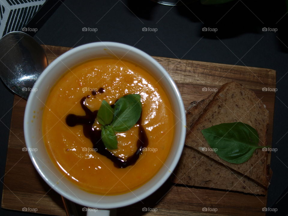 delicious pumpkin soup, decorated with basil and fresh bread