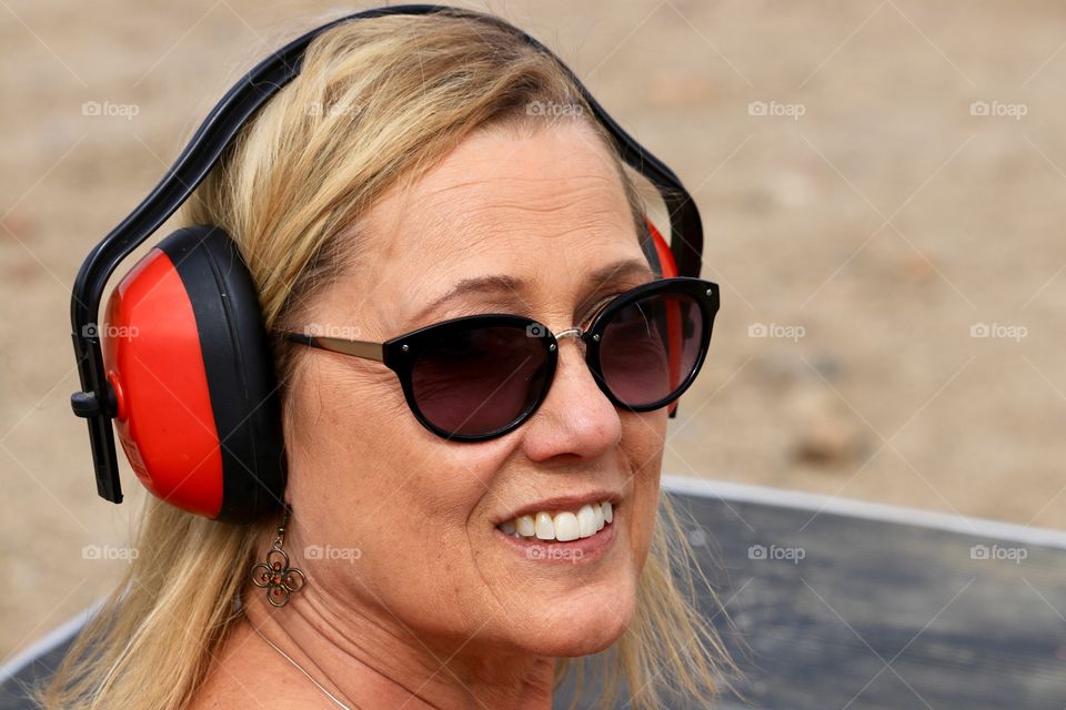 Blonde woman in sunglasses wearing ear protection