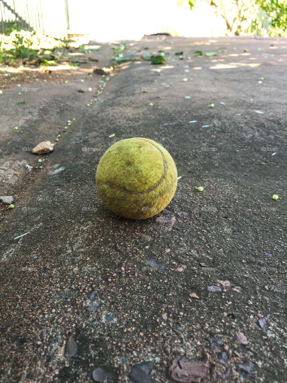 Dirty old tennis ball against dirty cement grunge