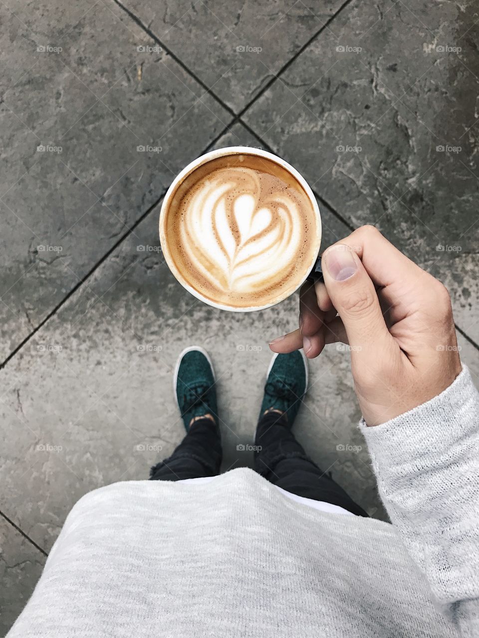 Holding a cappuccino in the rain. 