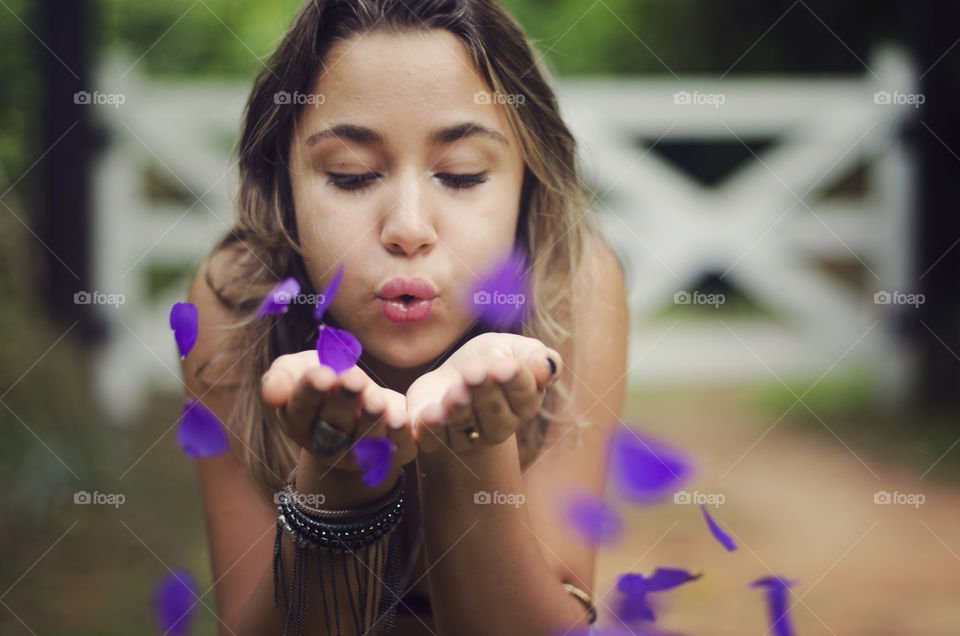 woman blowing off petals from her hands