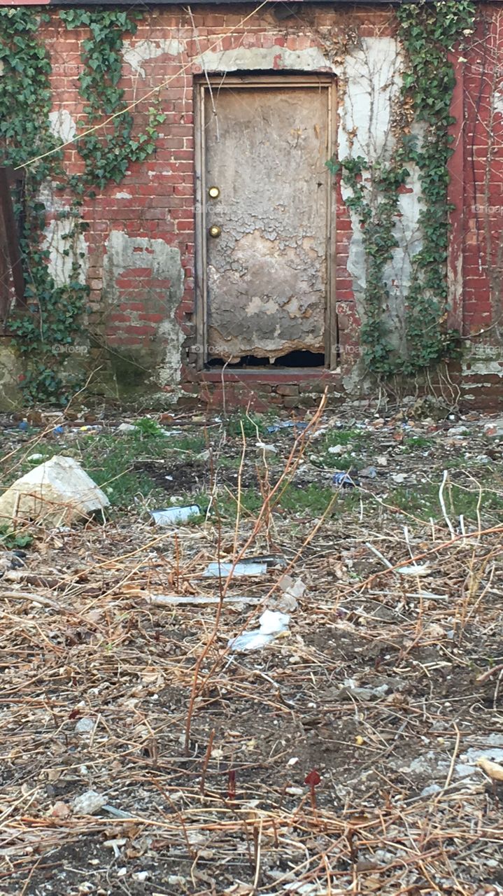 Beyond, lies a door. An old rusted steel panel amongst brick and earth. Is it keeping someone out, or keeping someone in?