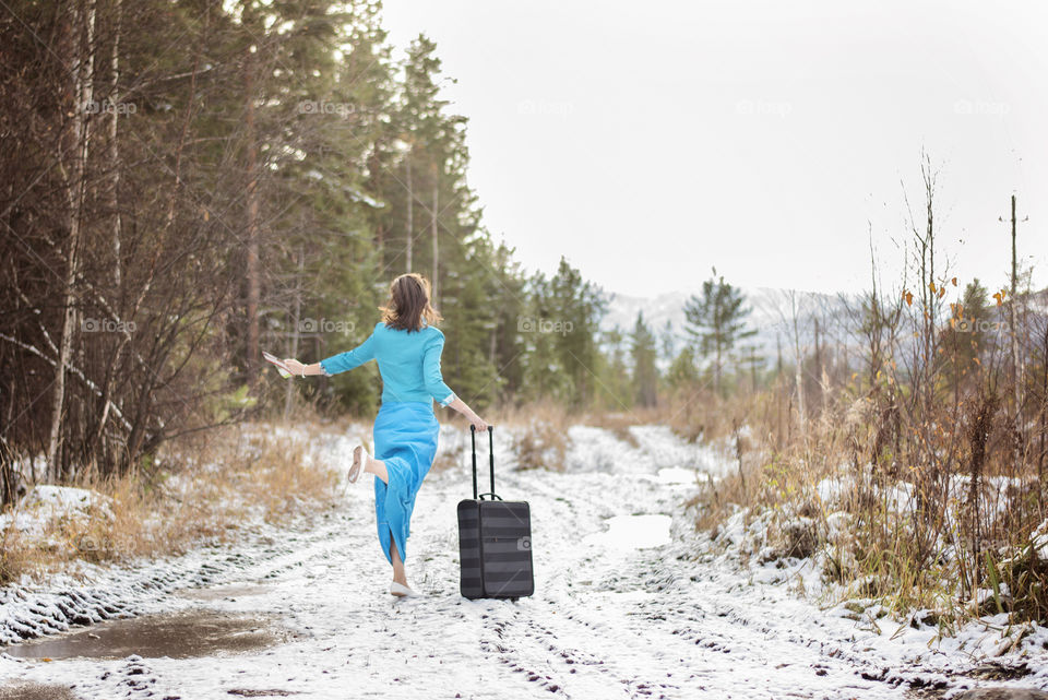 Women with luggage running in winter