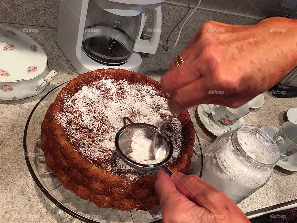 Busy hands baking a beautiful homemade cake.