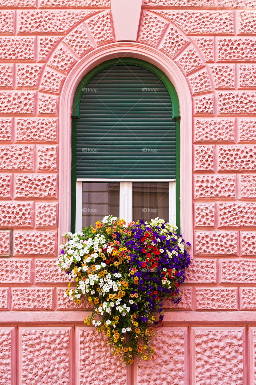 Window with floral bouquet, in the shape of a heart, in a nineteenth-century pink palace