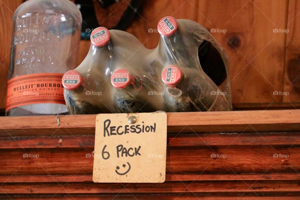 Recession Six pack bottles of beer, one missing bottle signage 