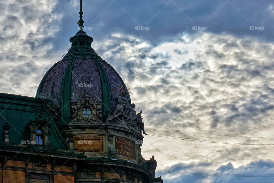 Sitting Sculptures on the Dome of the Building in Lviv again a Dramatic Sky 