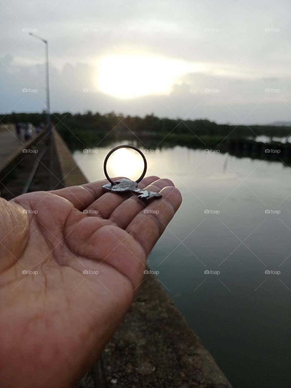 beautiful sunset view in bicycle key ring in human hand